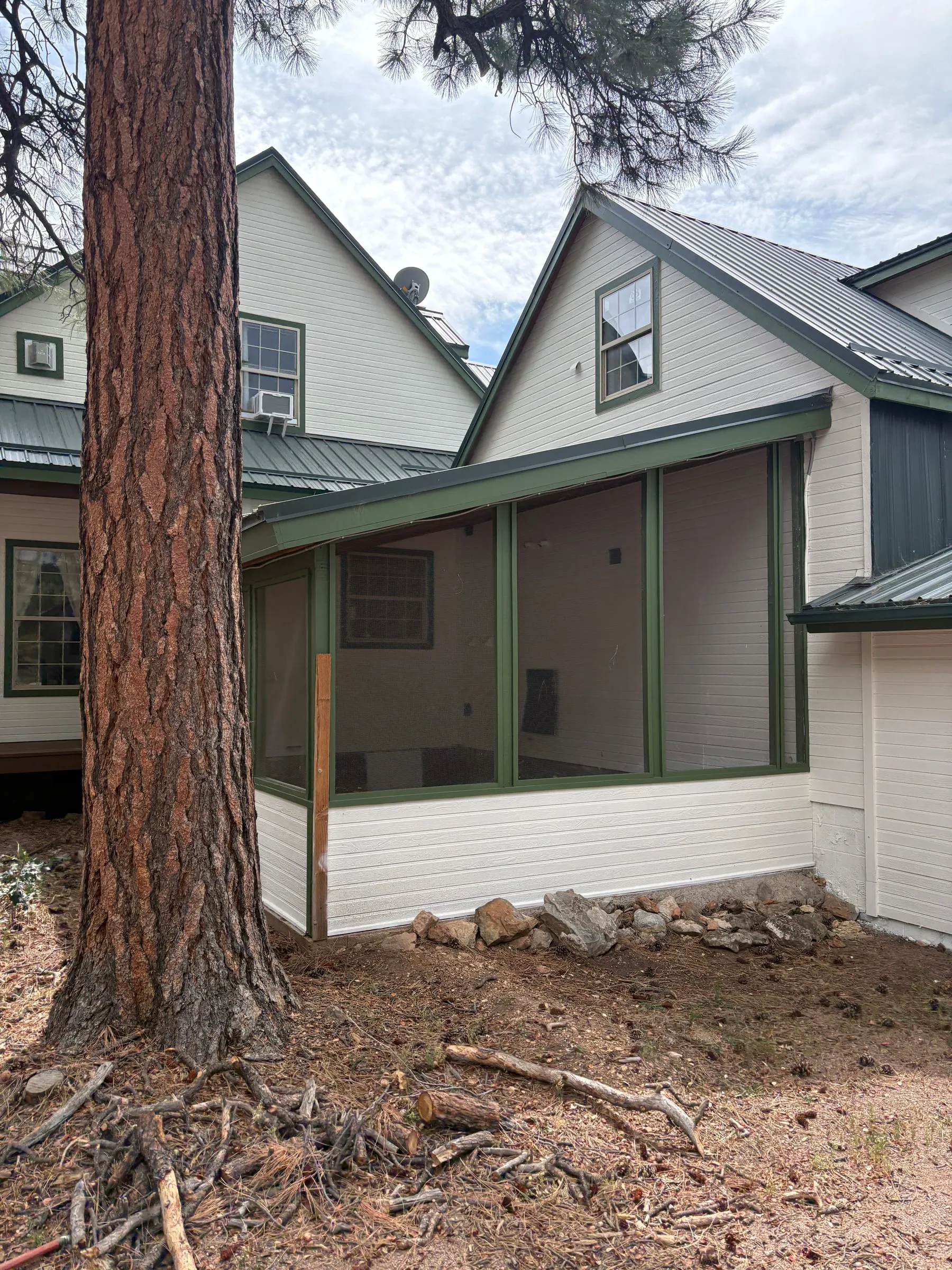 The dog run seen from the far end, running the length of the lodge wall under the eaves, screened on every side.