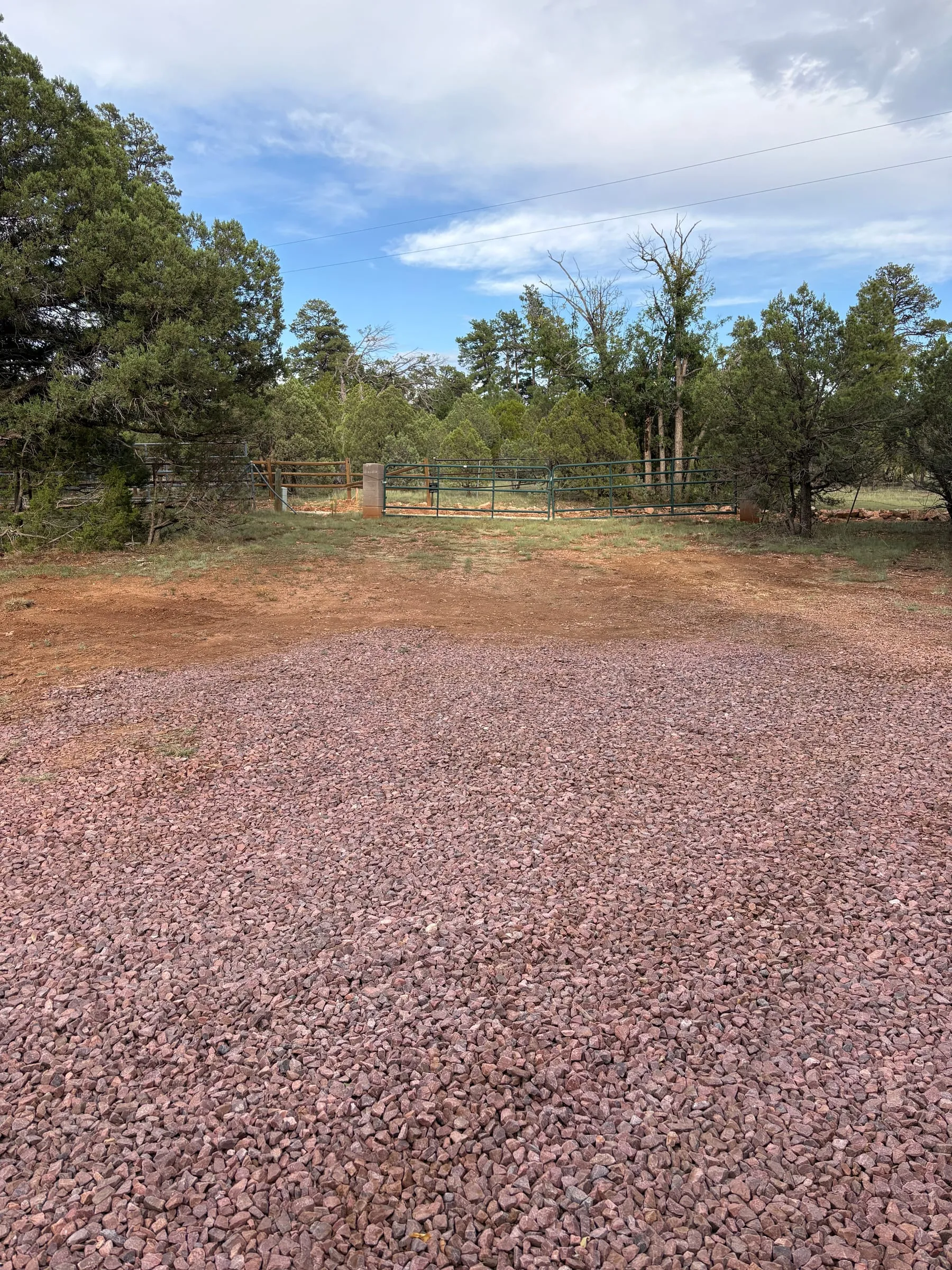 A second level, graveled area beside the gate, with room to park more trailers and towed vehicles.